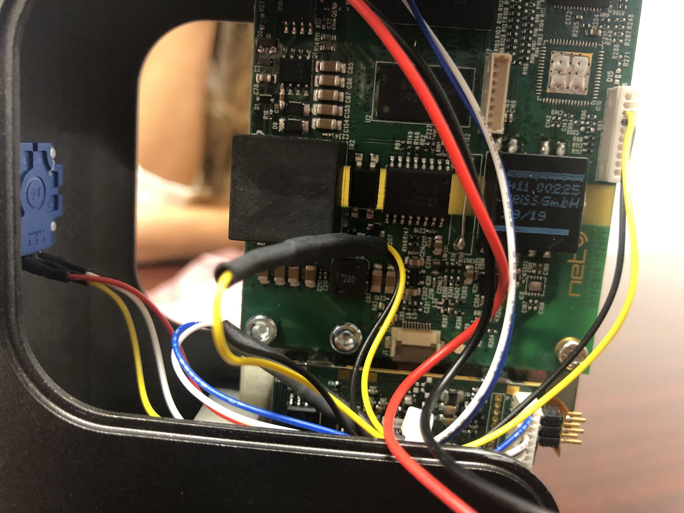 Circuit board and colored wiring inside an open handheld device.