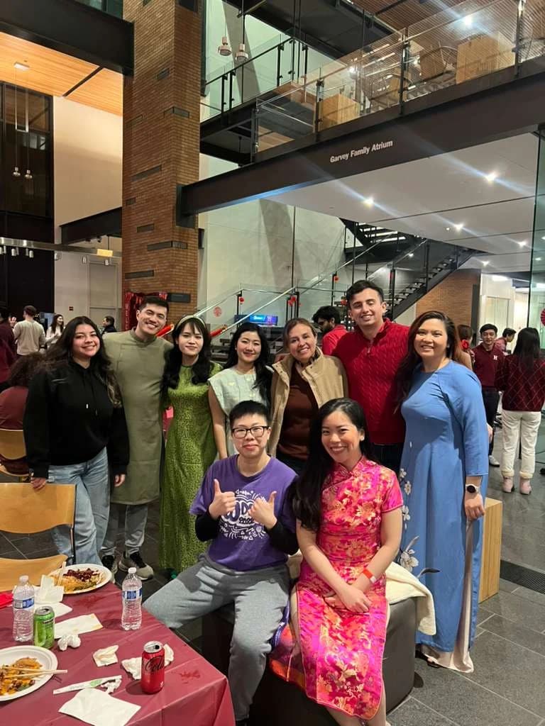 Classmates posing together beside a table at the Chinese New Year celebration.
