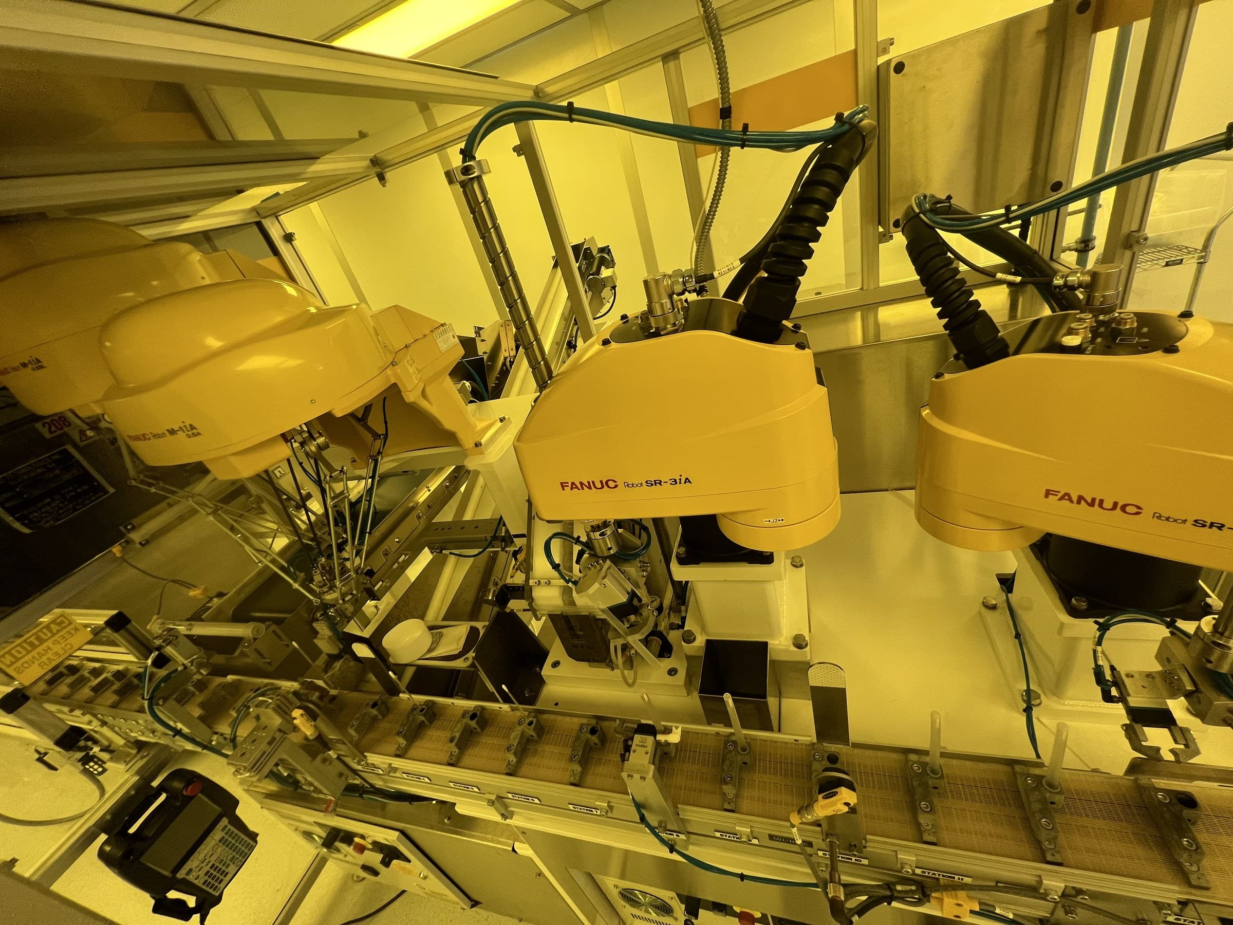 FANUC robots positioned over a production conveyor.