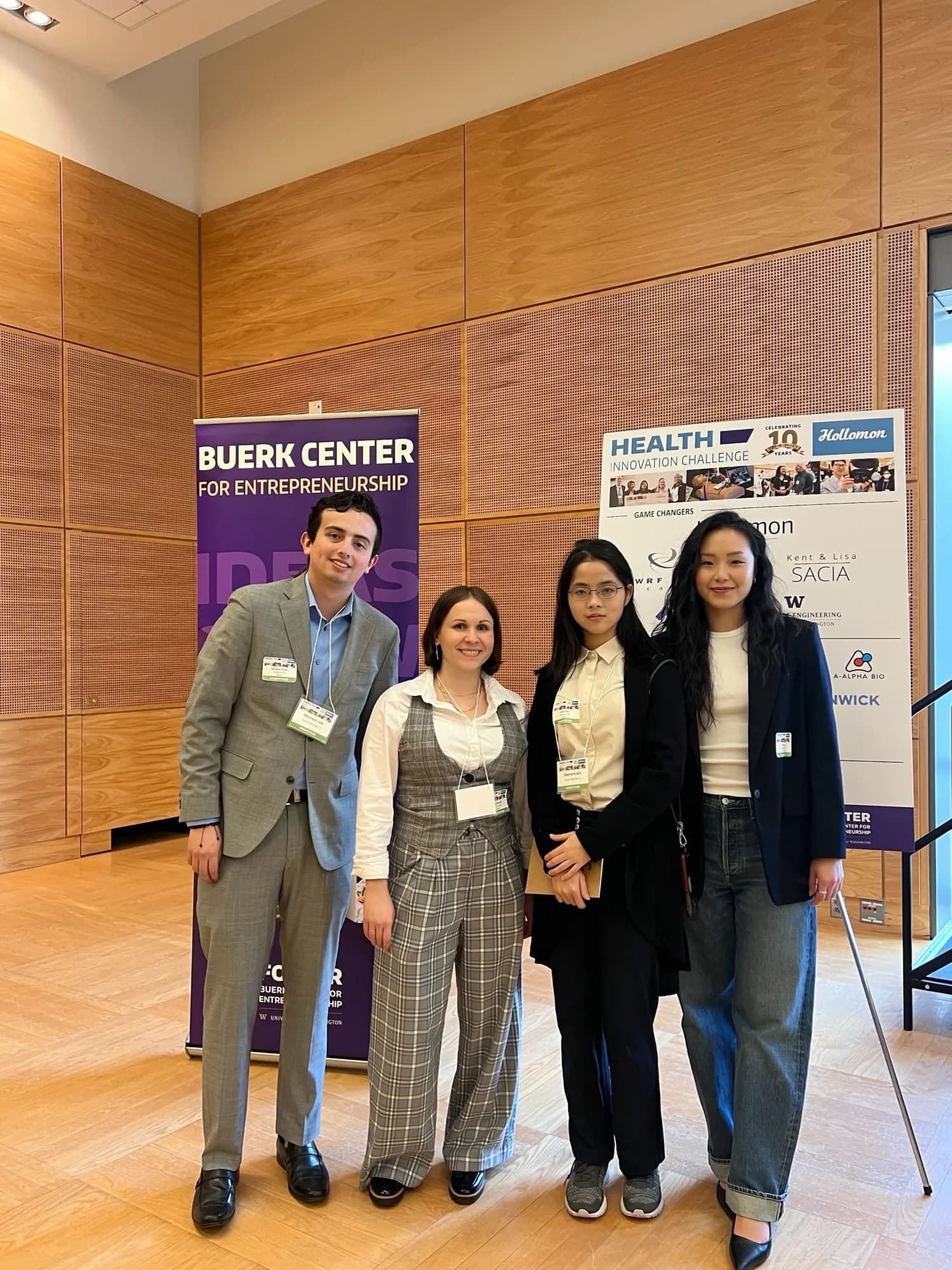 Four Mentem.lab team members beside a Buerk Center for Entrepreneurship banner and a Hollomon Health Innovation Challenge sign.